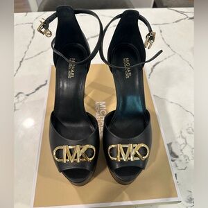 Michael Kors Martina Peep Toe Pump in black leather with gold details/hardware.